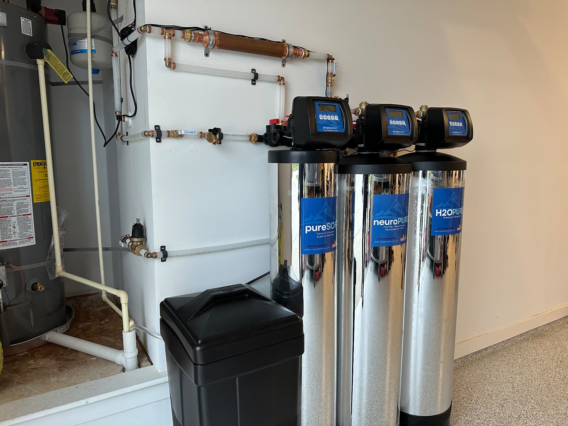 Multi-system Simply Water installation with H2OPURE, neuroPURE, and pureSOFT tanks in a finished garage